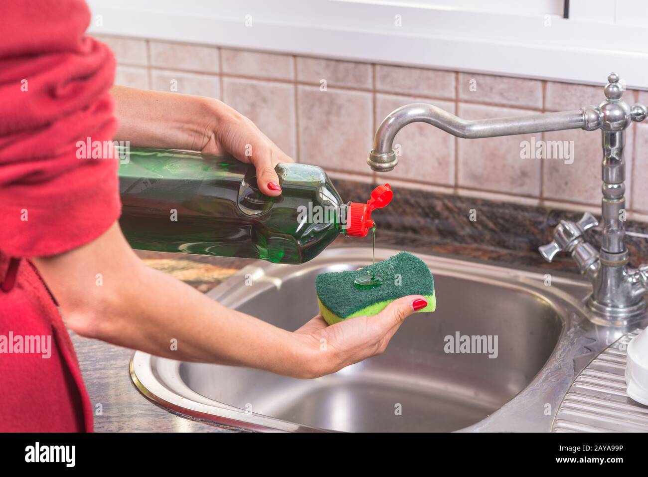 https://c8.alamy.com/compes/2aya99p/mujer-con-manicura-roja-poniendo-detergente-en-el-estropajo-para-lavar-los-platos-2aya99p.jpg