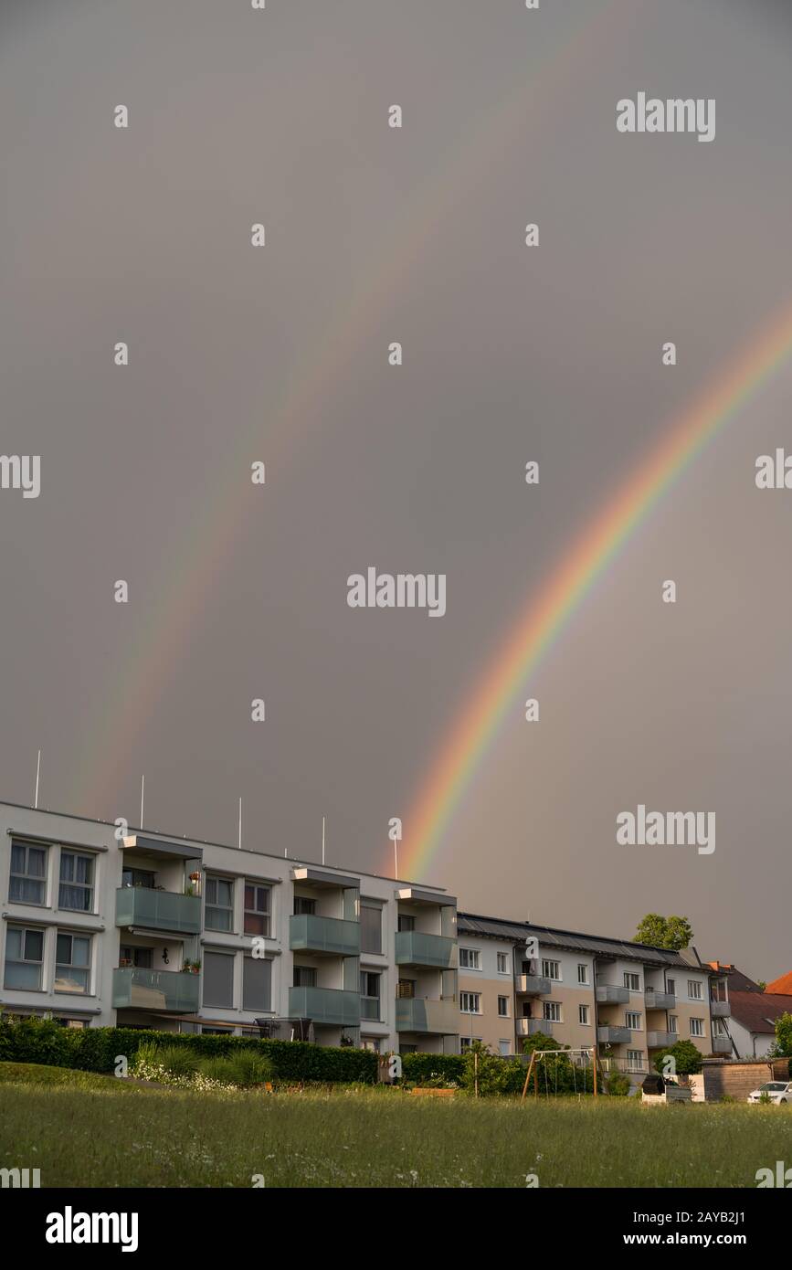 arco iris doble en una tormenta sobre casa residencial - formato retrato Foto de stock