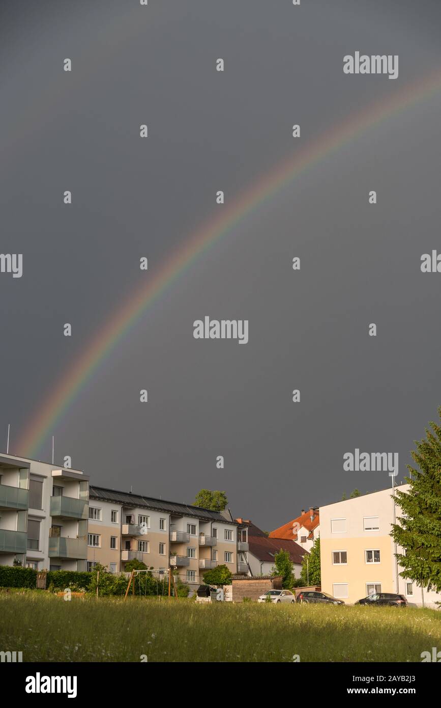 arco iris brillante sobre casas residenciales en el país - retrato Foto de stock