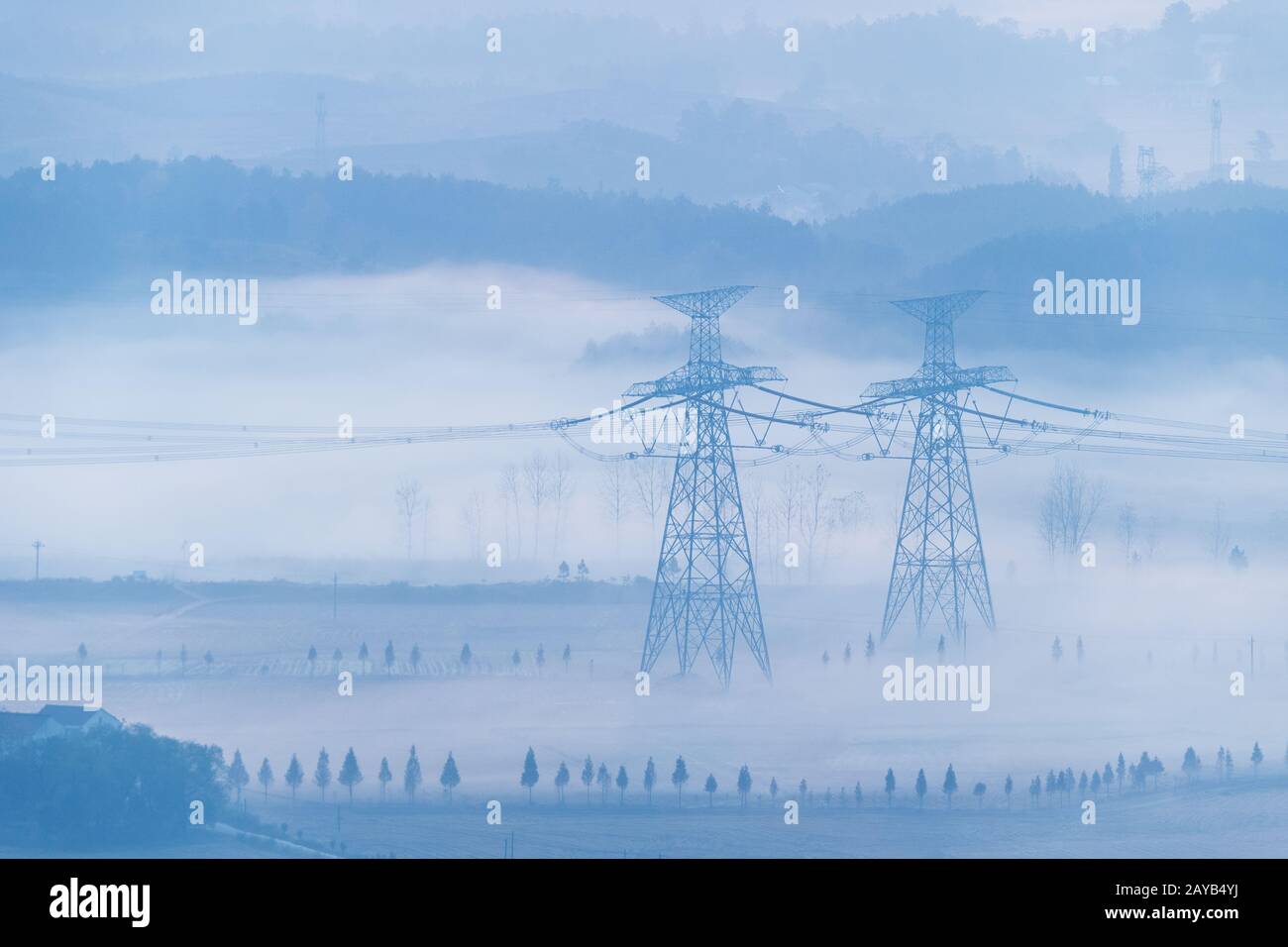 torres de transmisión de potencia en la niebla de la mañana Foto de stock