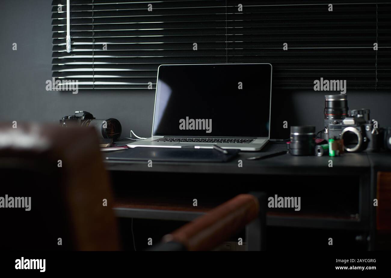 Espacio de trabajo sobre mesa negra de un fotógrafo o diseñador con portátil Foto de stock