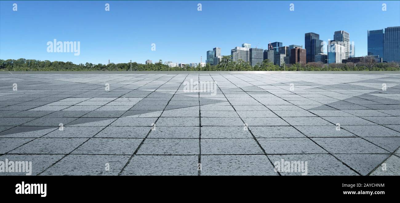 Piso vacío de mármol con paisaje urbano y horizonte en un cielo azul claro Foto de stock