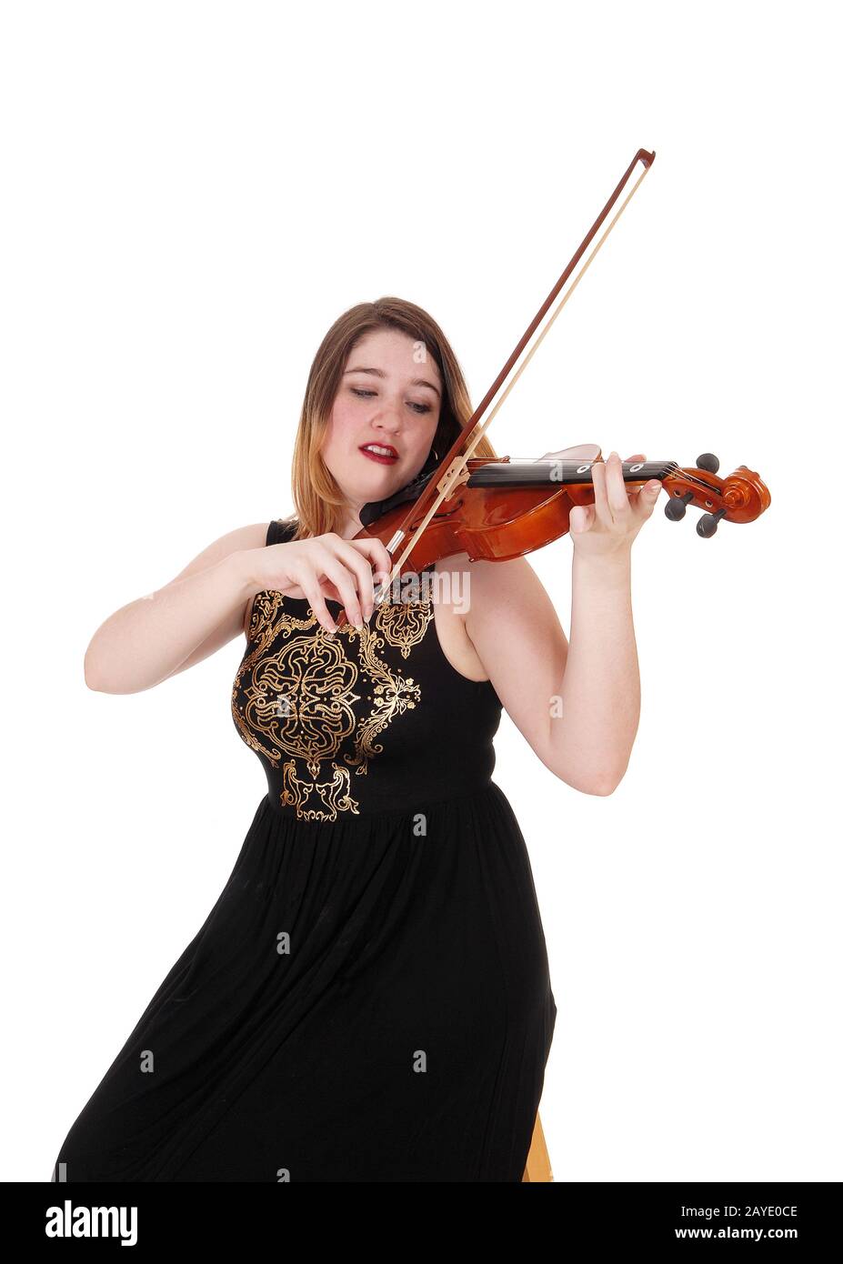 Mujer sentada con un largo vestido negro tocando el violín Foto de stock