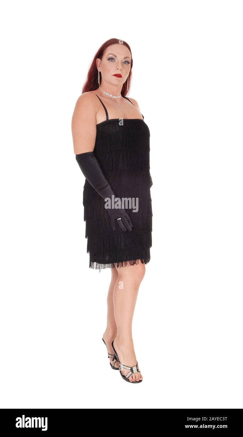 Una mujer de edad media de pie con un vestido negro Foto de stock