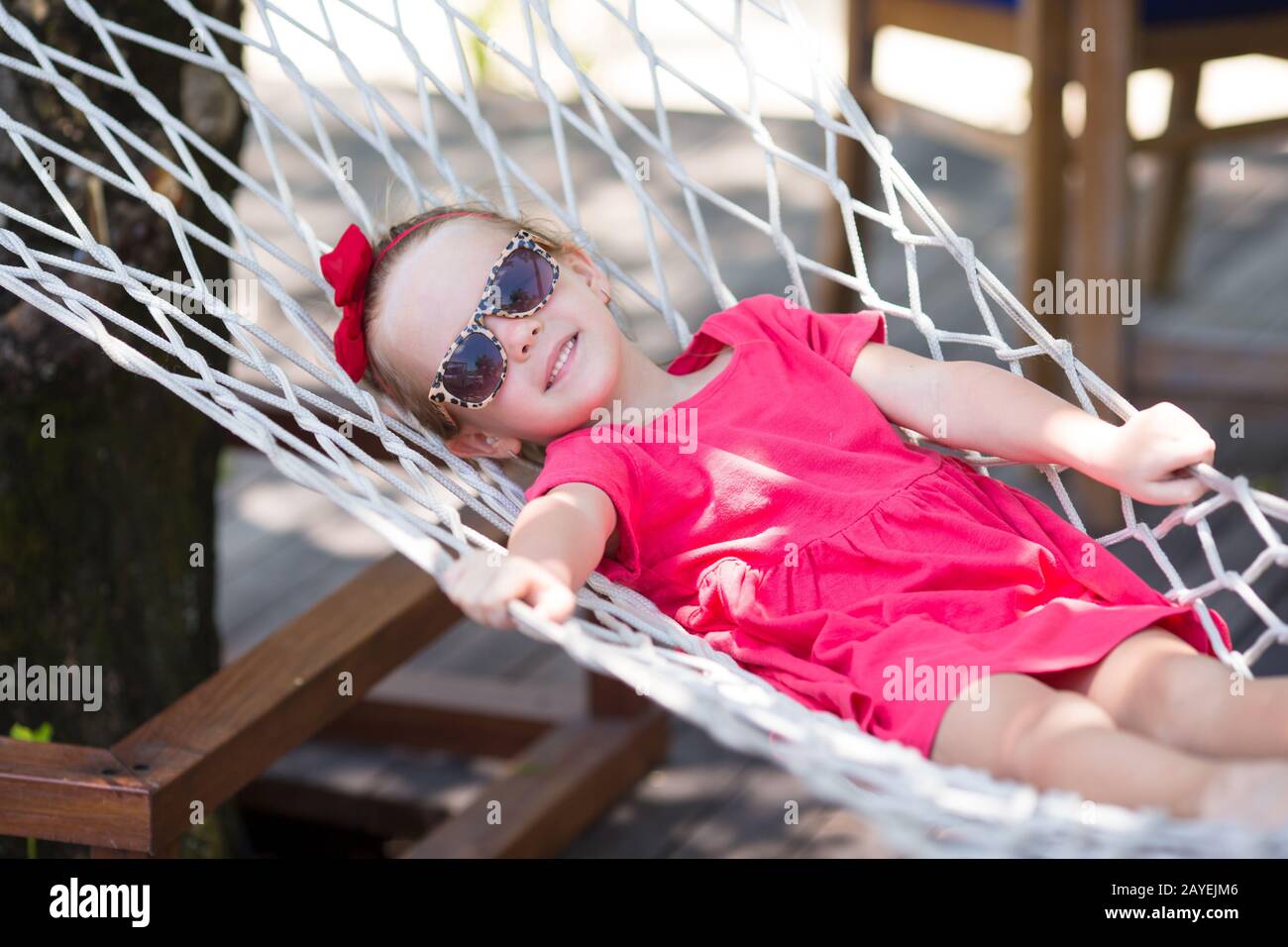 Adorable niña en relajantes vacaciones tropicales en hamaca Foto de stock