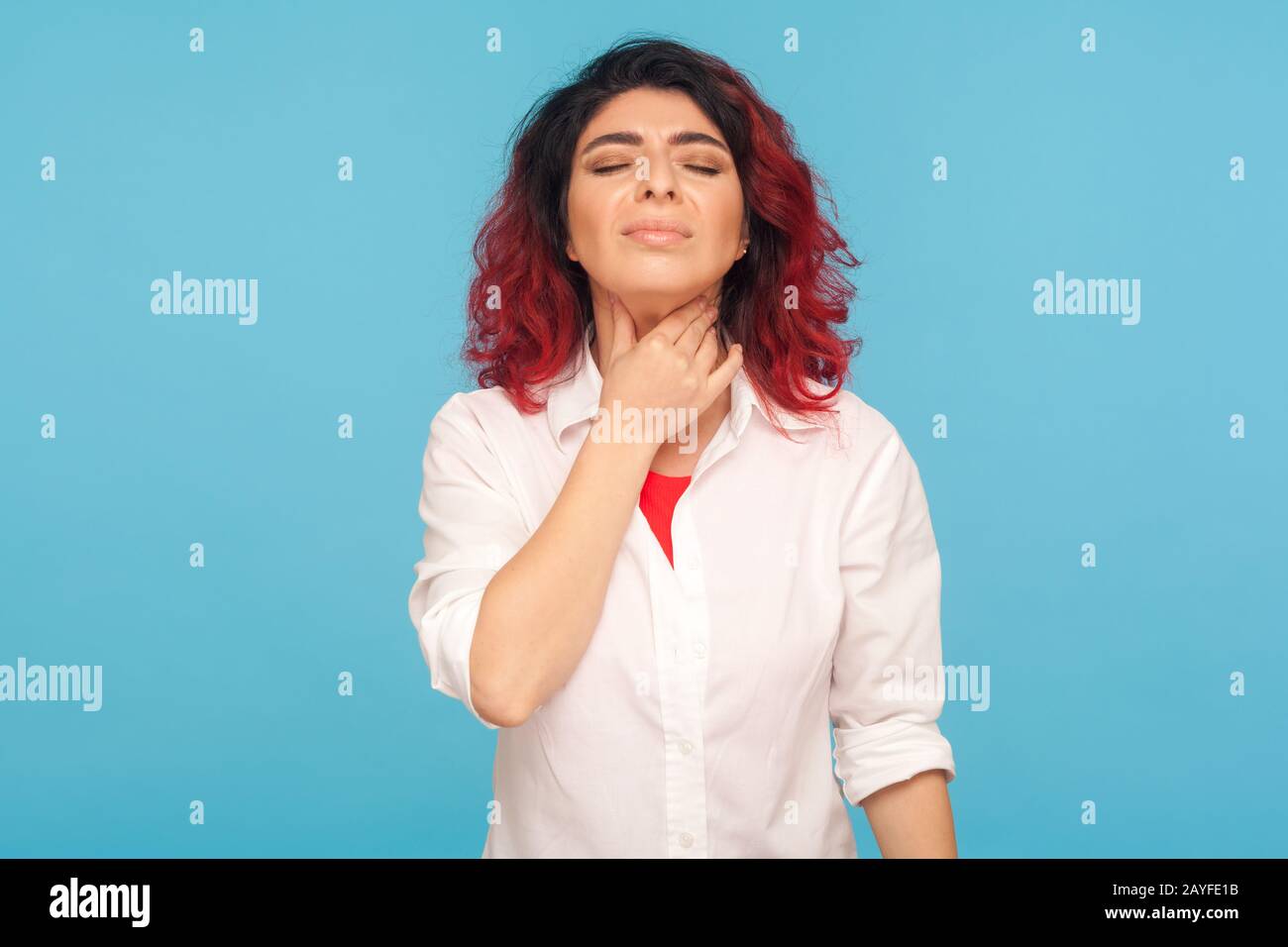 Resfriados y epidemia de gripe. Retrato de una mujer malsana con un cabello rojo de lujo tocando el cuello, sufriendo dolor de garganta, sintiendo dolor en las amígdalas, difícil de tragar Foto de stock