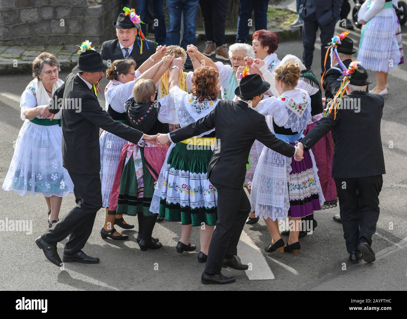15 de febrero de 2020, Brandeburgo, Neu Zauche: Las parejas en el original  Sorbian-Wendish trajes de fiesta bailan en una calle durante el tradicional  Zapost, el carnaval. 95 parejas casadas y 33