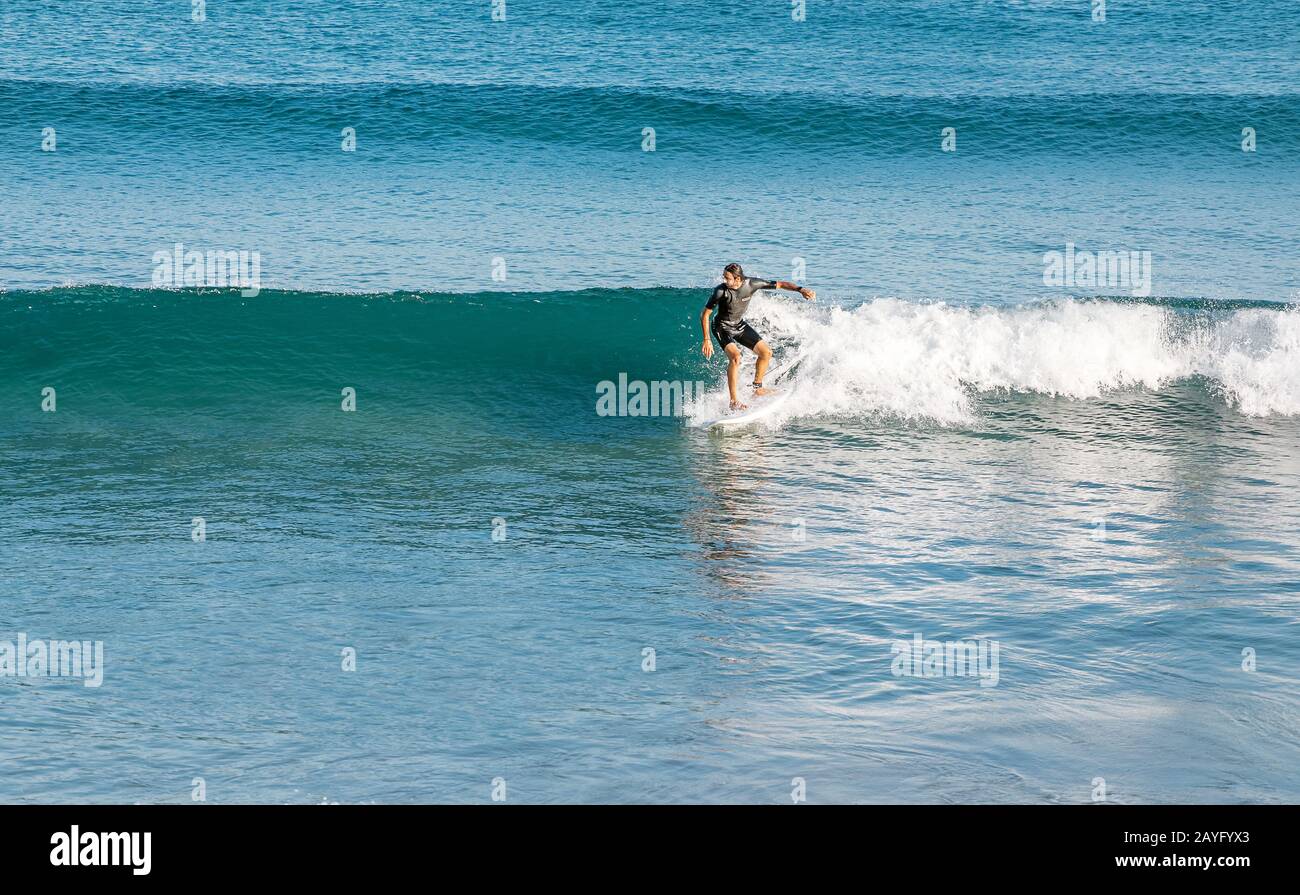 16 DE JULIO de 2018, TARRAGONA, ESPAÑA: Los surfistas se pasean por las olas del mar. Deporte extremo y hobby concepto Foto de stock