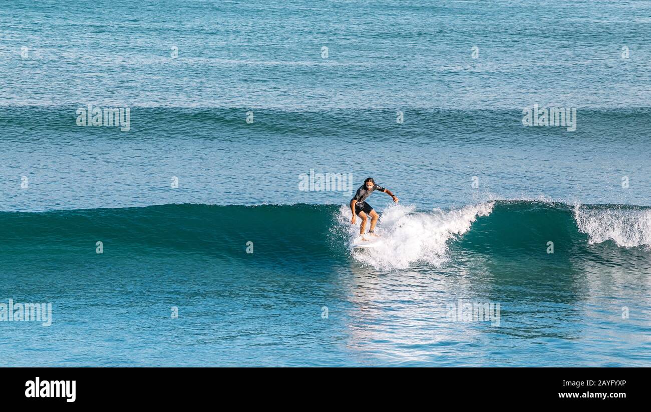 16 DE JULIO de 2018, TARRAGONA, ESPAÑA: Los surfistas se pasean por las olas del mar. Deporte extremo y hobby concepto Foto de stock