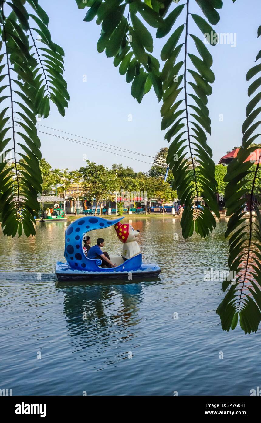 PATHUMTHANI, TAILANDIA – DIC. 21, 2018: Niños y familias disfrutando en un colorido bote de juguete en el lago en el parque de diversiones Dream World cerca de Bangkok. Foto de stock