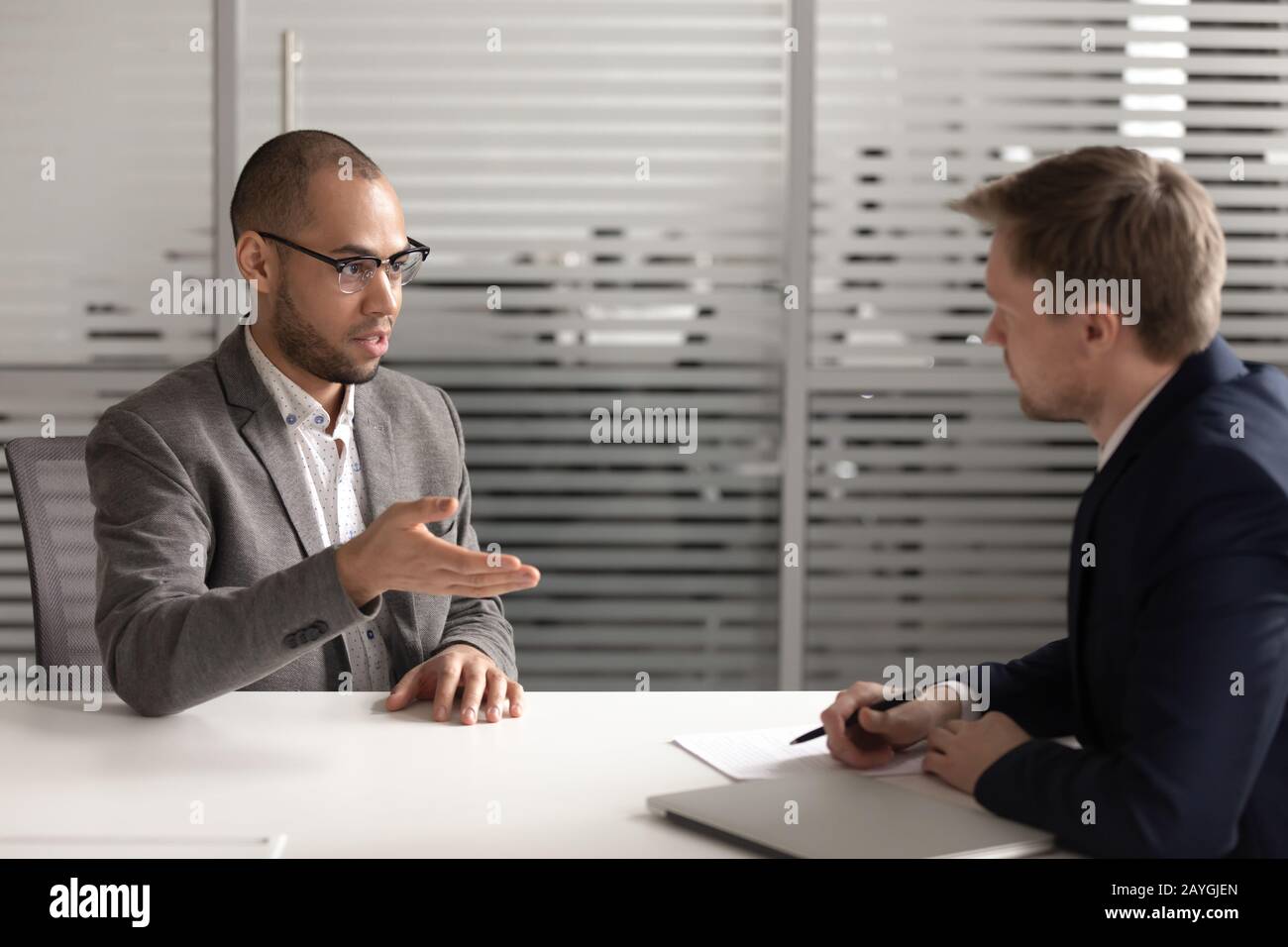 Un hombre serio solicitante habla con el empleador en la entrevista Foto de stock