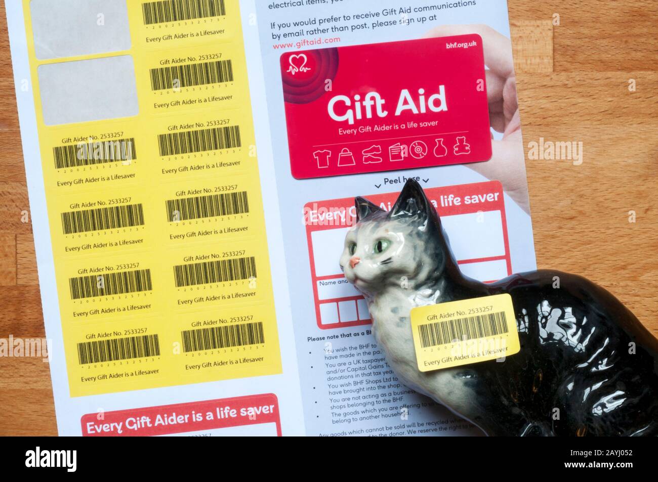 Un ornamento de gato de porcelana con una pegatina De Gift Aid para donación a la organización benéfica de la British Heart Foundation. Foto de stock