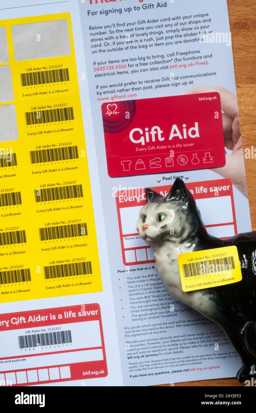 Un ornamento de gato de porcelana con una pegatina De Gift Aid para donación a la organización benéfica de la British Heart Foundation. Foto de stock