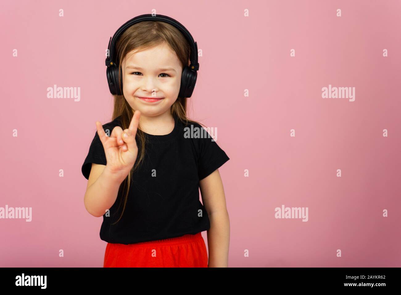 Siguiendo la canción lindo fanático de la música con auriculares  inalámbricos niña pequeña escuchando música niña pequeña usando audífonos  estéreo niña pequeña usando tecnología para el ocio o la educación