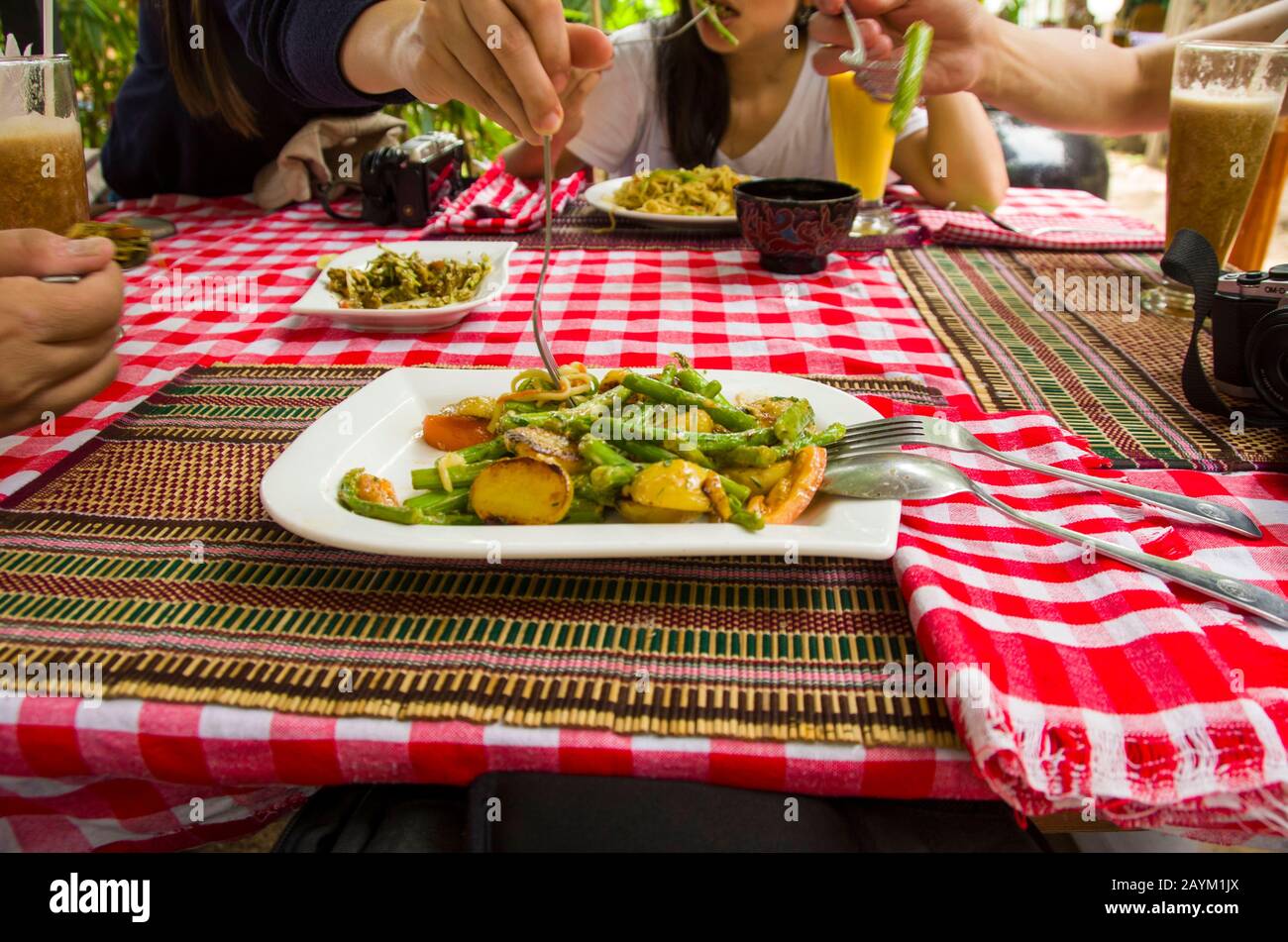 Amigos compartiendo comida durante el almuerzo mientras viajan juntos Foto de stock