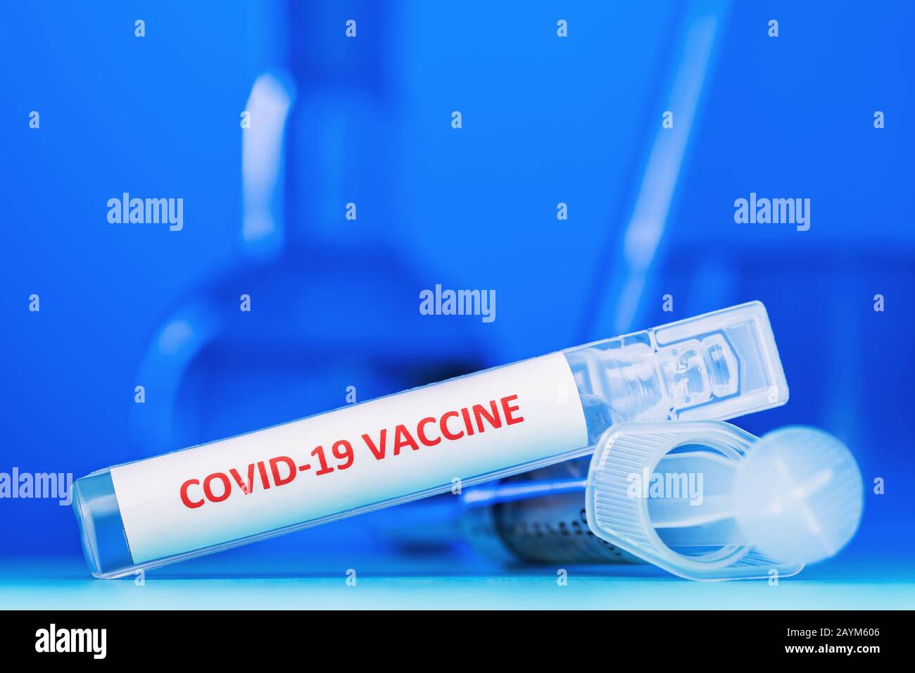 Ampolla con vacuna contra coronavirus COVID-19 sobre fondo azul, primer plano. El concepto de la victoria sobre el virus Foto de stock