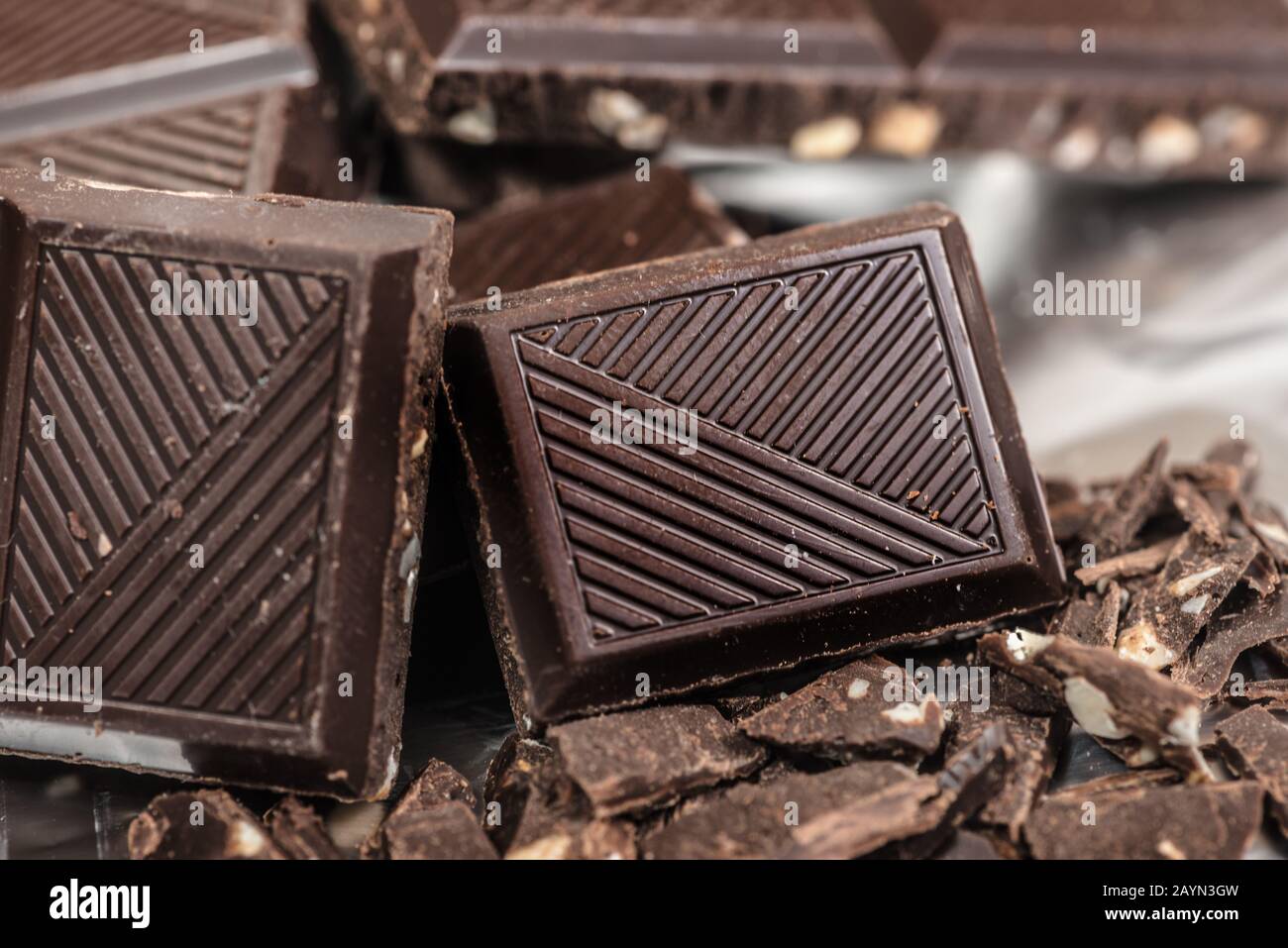 Barra de chocolate pone trozos de fondo con nuez de almendra, cerca Foto de stock