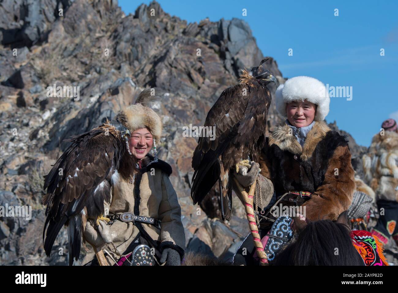 Dos chicas adolescentes de cazadores de águilas kazakas y sus águilas  doradas a caballo en el camino al Festival del Águila Dorada cerca de la  ciudad de Ulgii (Ölgii Fotografía de stock -