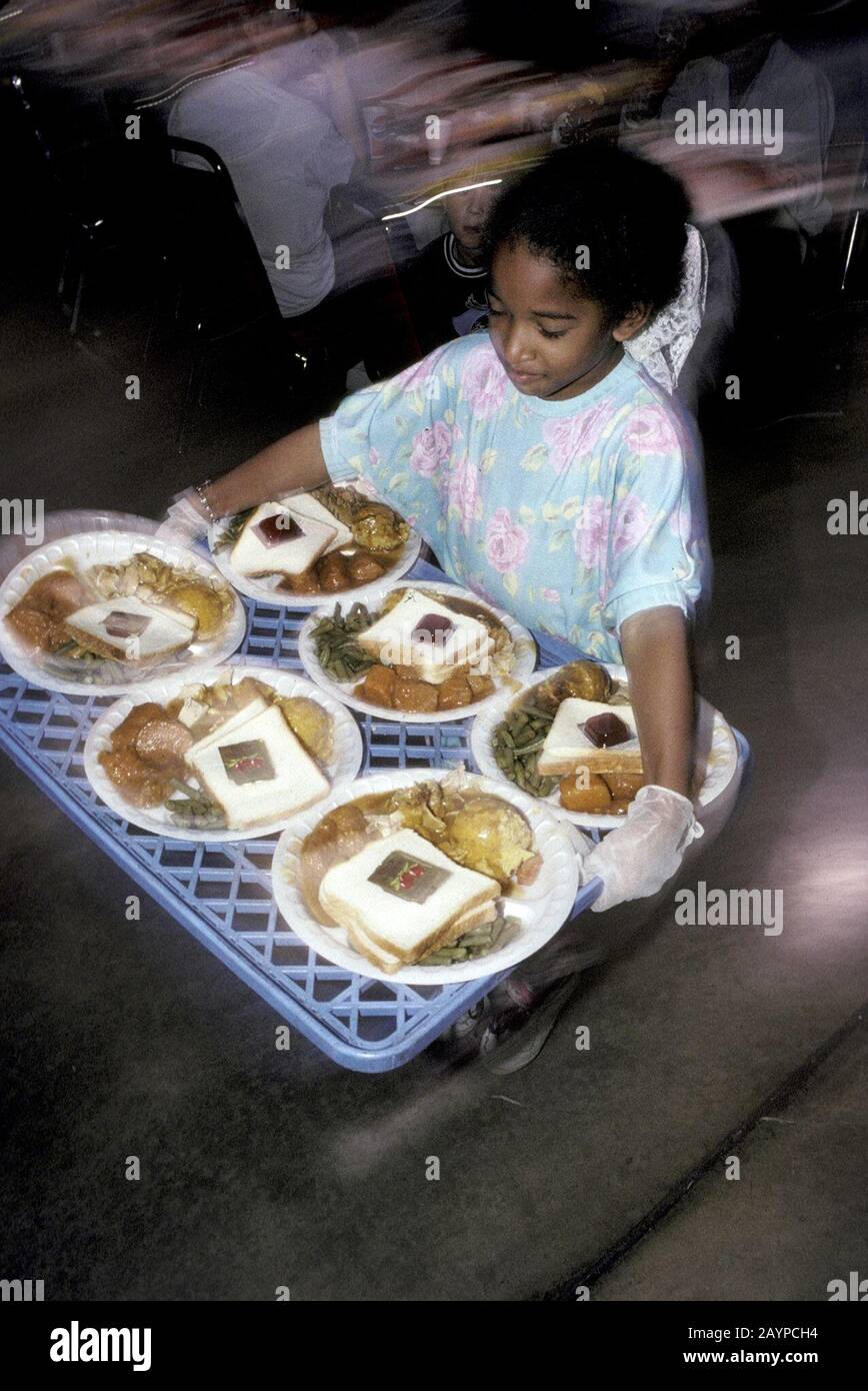 San Antonio, Texas: Los jóvenes voluntarios llevan una bandeja llena de  platos de comidas en la cena anual gratuita de Acción de Gracias para  personas desfavorecidas. ©Bob Daemmrich Fotografía de stock -