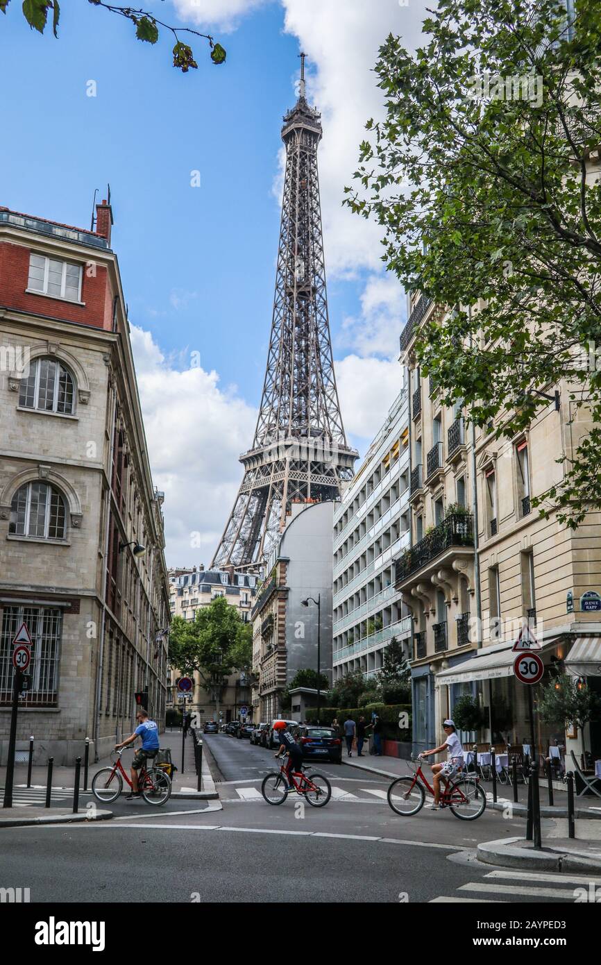 Escena callejera con ciclistas utilizando el cruce y la Torre Eiffel en el fondo París, Francia, Europa Foto de stock