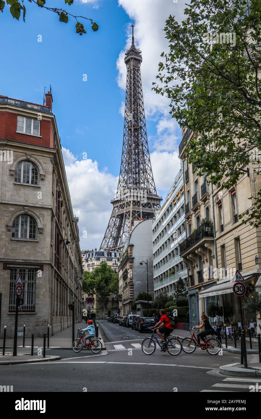 Escena callejera con ciclistas y la Torre Eiffel al fondo París, Francia, Europa Foto de stock