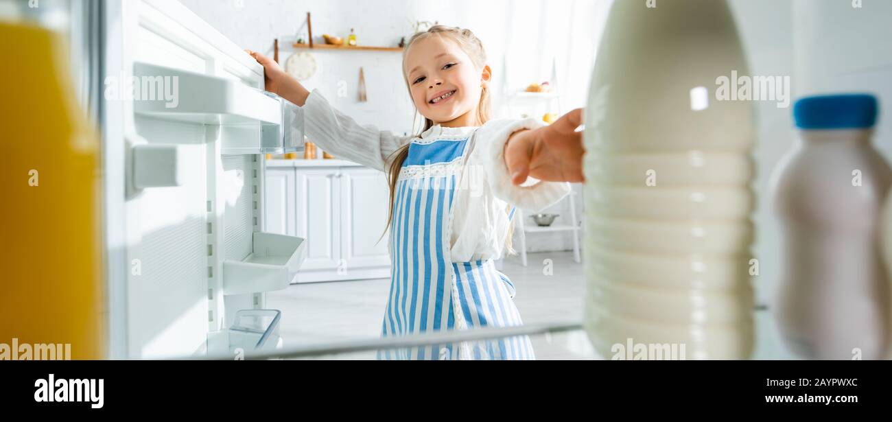 foto panorámica de un niño sonriente tomando una botella con leche de ...