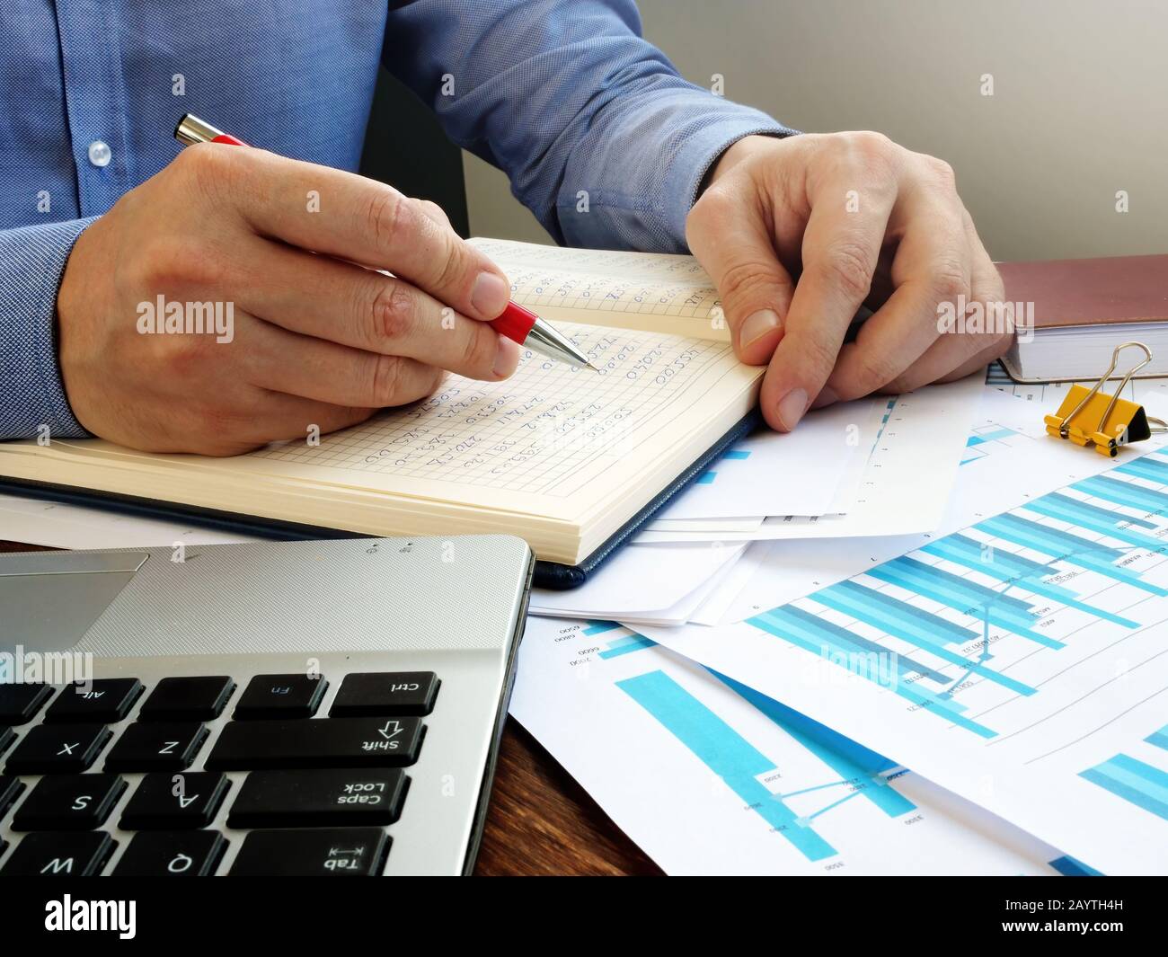 Businessman hace cálculos financieros y escribe en el libro de contabilidad  Fotografía de stock - Alamy