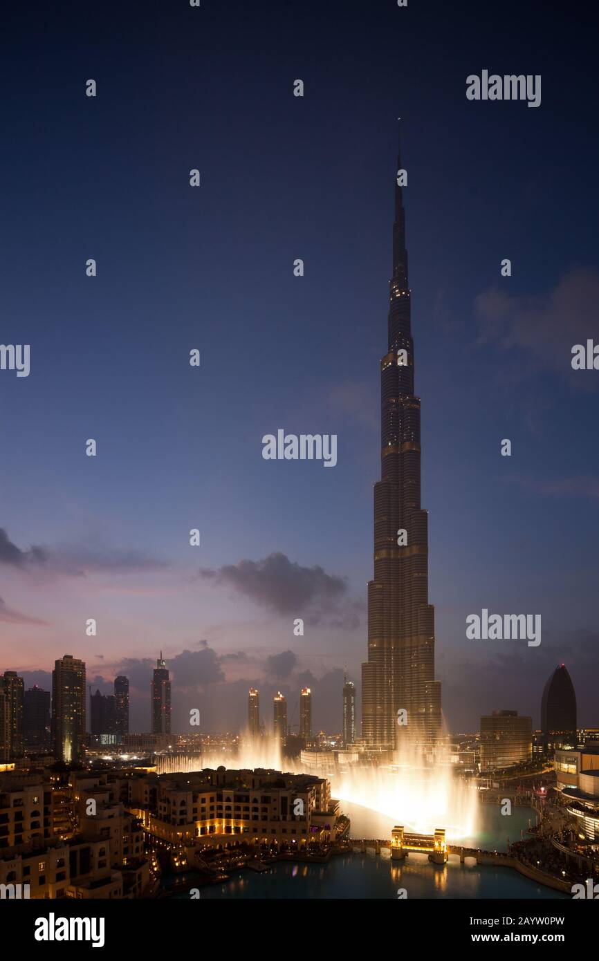 El espectáculo de la fuente de Dubai comienza justo después de la puesta de sol con el Burj Khalifa al fondo. Foto de stock