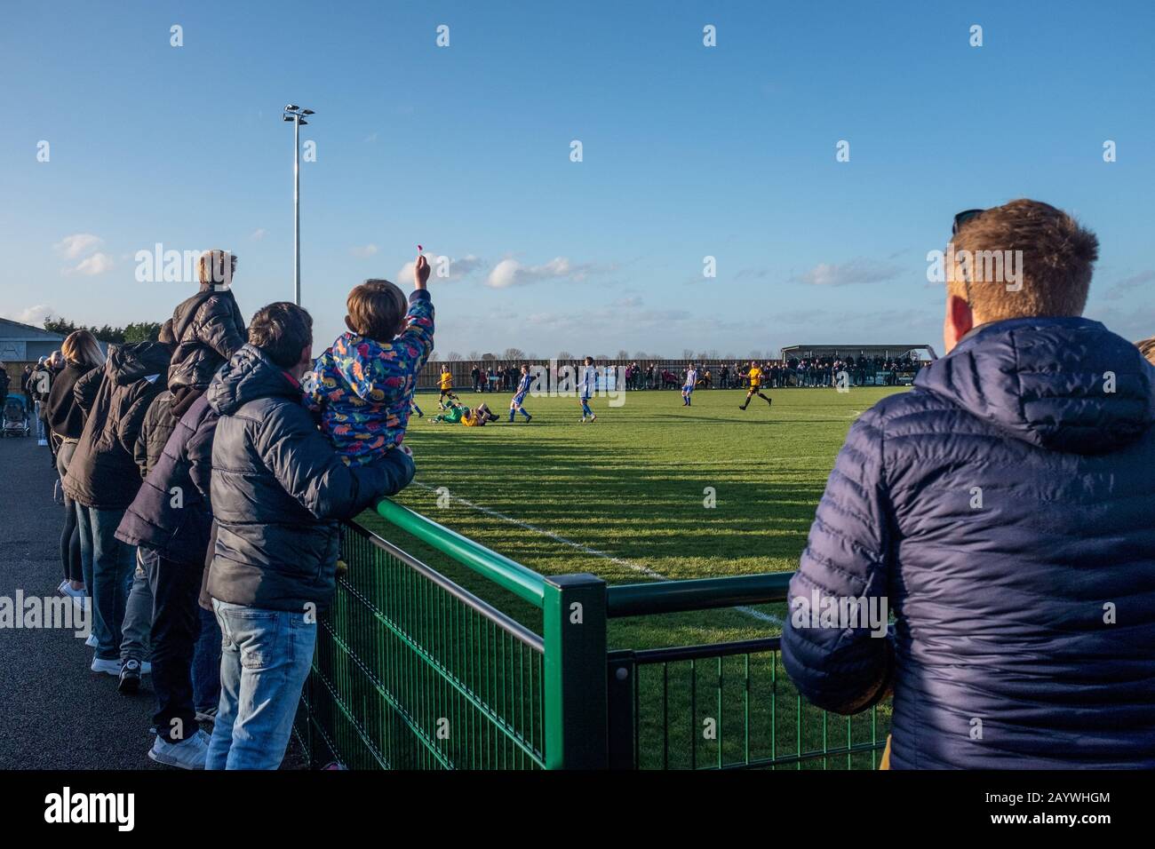 Espectadores viendo un partido de fútbol en el estadio STOTFOLD FC JSJ, New Roker Park, Stotfold en la soleada tarde. Foto de stock