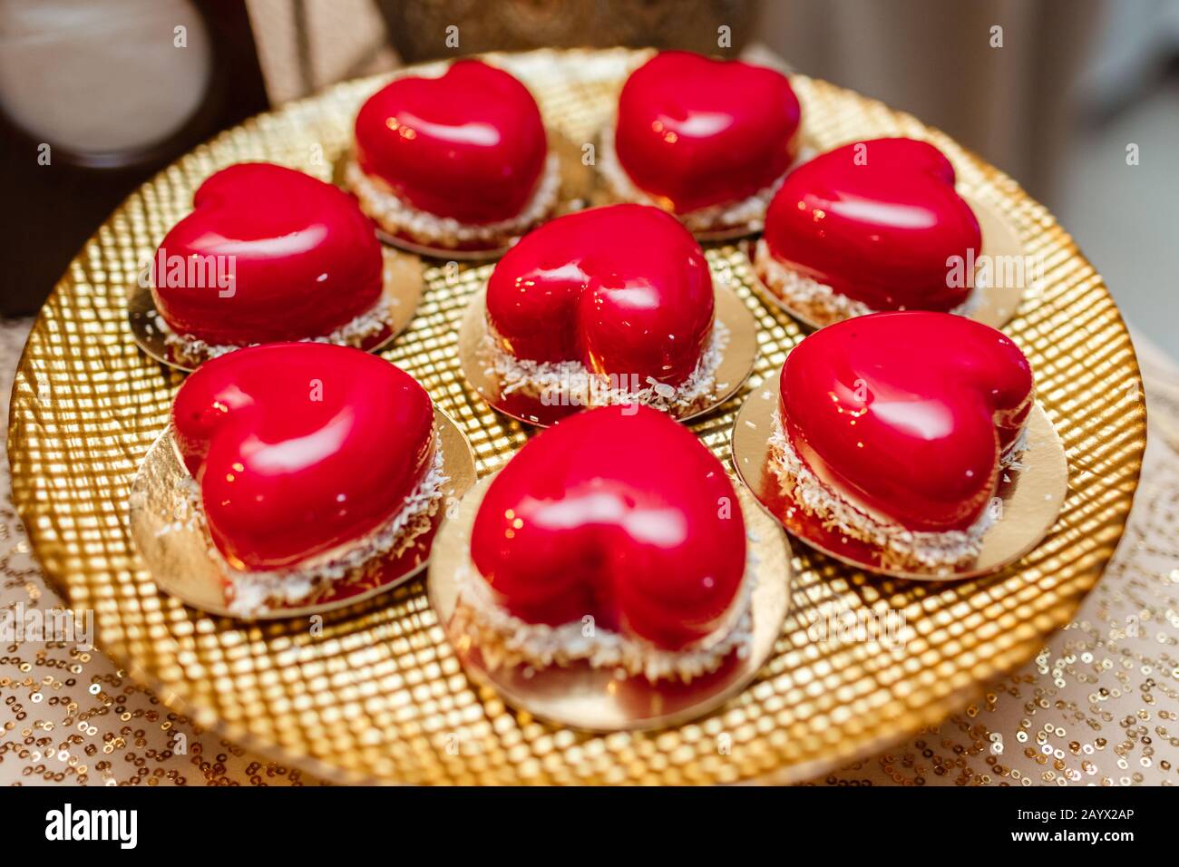 bar de caramelos. Pastel de mousse de moda en forma de corazón con glaseado  de espejo rojo y copos de coco en placa de oro. Postre moderno. Día de San  Valentín Fotografía