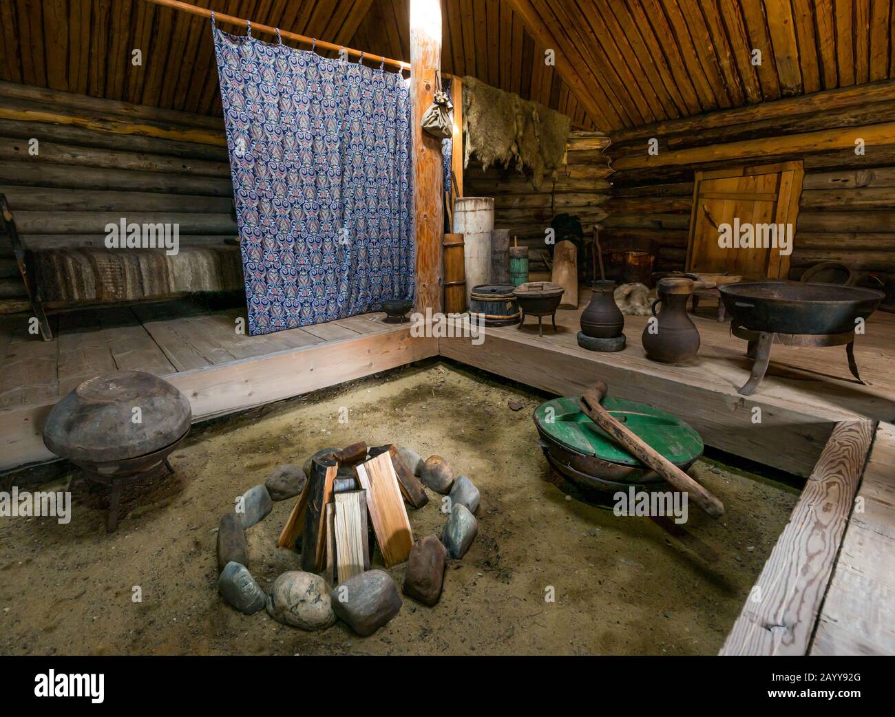 Interior primitivo de cabaña de madera que representa el estilo de vida tradicional, Museo Taltsy de Arquitectura de madera, Región de Irkutsk, Siberia, Rusia Foto de stock
