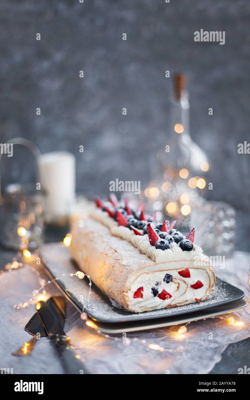 Pastel de rollo de merengue con crema y bayas frescas Foto de stock