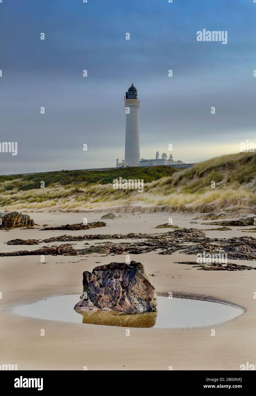 LOSIEMOUTH MORAY FIRTH ESCOCIA UN INVIERNO WEST BEACH ROCK AND ROCK POOL COVESEA FARO SOBRE LA PLAYA DE ARENA Foto de stock