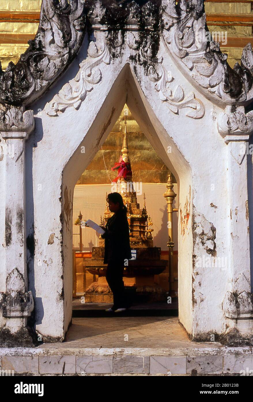 Tailandia: Un devoto budista rodea el chedi principal en Wat Phra That Chae Haeng, Nan, Norte de Tailandia. Wat Phra que Chae Haeng data de 1355 y fue construido durante el reinado de Ore Kan Muang. Nan data de mediados del siglo 14th y durante gran parte de su historia fue un reino aislado. La ciudad actual se extiende a lo largo de la orilla derecha del río Nan. Foto de stock