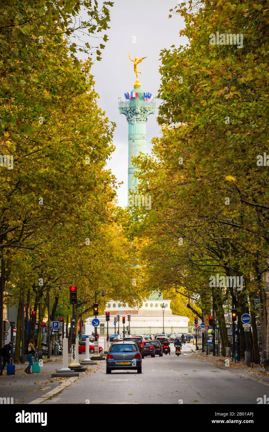 París, Francia - 11 de noviembre de 2019: La parte superior del monumento de la Bastilla que aparece entre los árboles, desde el Boulevard Henri IV, un bosque largo Foto de stock