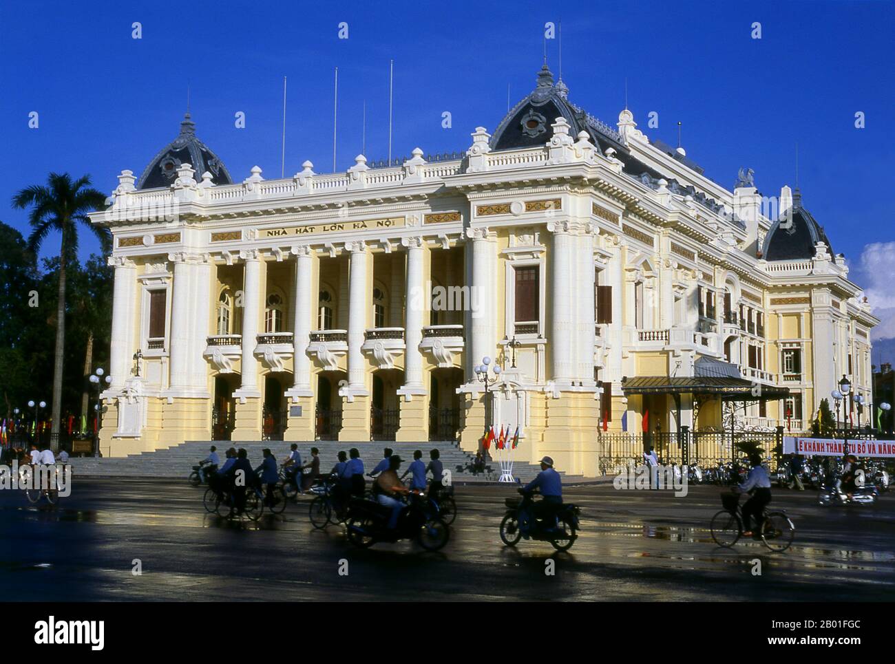 Vietnam: Teatro de la Ópera, Hanoi. La Ópera de Hanoi está inspirada en la Ópera de París diseñada por Charles Garnier y terminada en 1875. Es conocida en vietnamita como Nha Hat Lon o 'Big Song House' y abrió sus puertas en 1911 incorporando los mismos grandes elementos del diseño napoleónico de Garnier. Sigue siendo la pieza central de la arquitectura francesa no solo en Hanoi, sino en toda la antigua Indochina francesa y su presencia adornaría cualquier ciudad del mundo. Antes de la Segunda Guerra Mundial, la Ópera estaba en el centro de la vida cultural francesa en Hanoi. Después de la independencia, sin embargo, gradualmente cayó en mal estado. Foto de stock