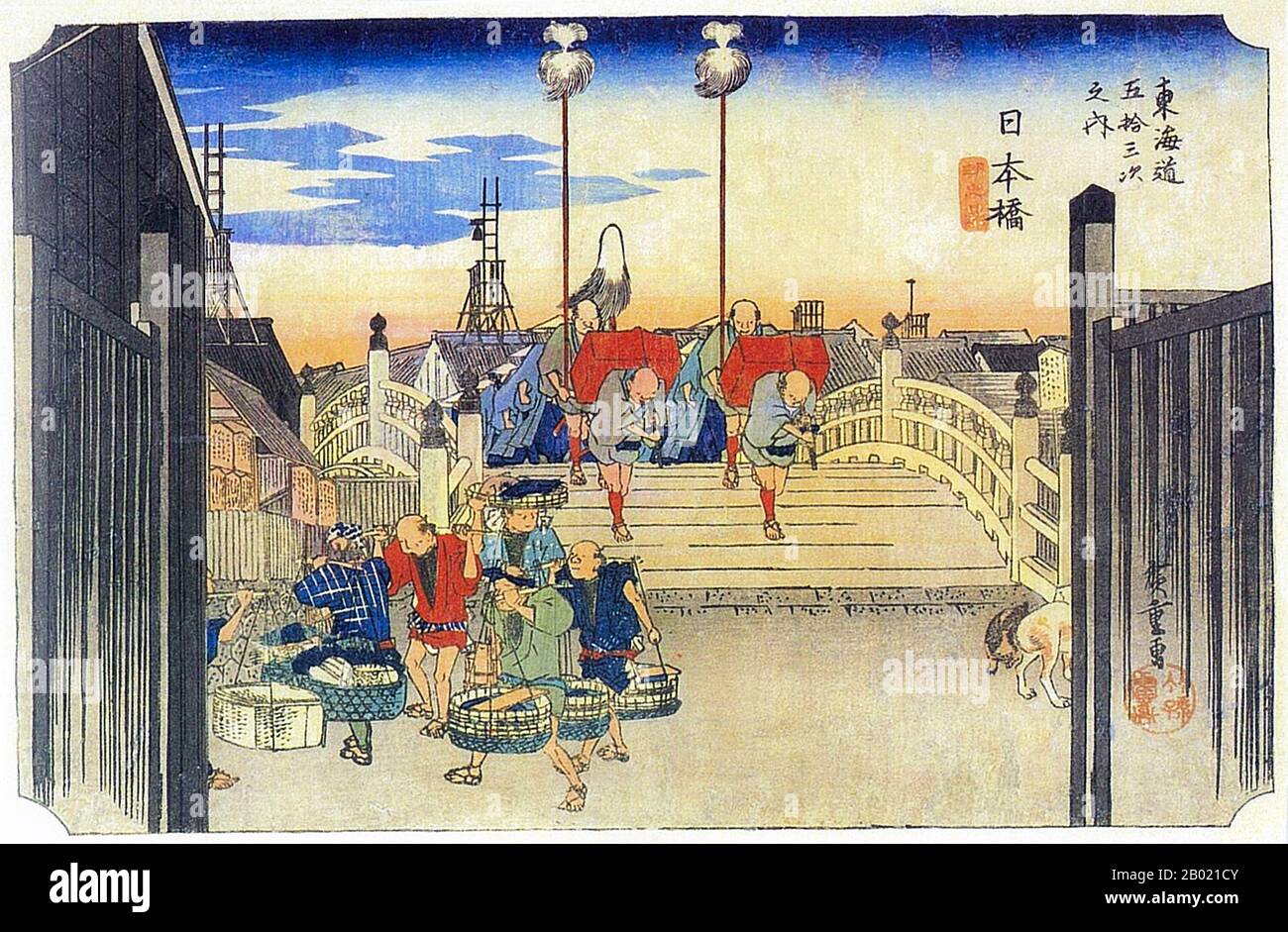 Nihonbashi: Vista al otro lado del puente Nihon, Edo, desde donde todas las distancias fueron medidas con un daimyo's Cortège que se encuentra a la vista sobre la cumbre. En primer plano está un grupo de cinco vendedores de pescado (y un sexto parcialmente oculto) saliendo del camino, a la izquierda, y dos perros a la derecha. Este puente estaba situado en el centro de Edo y era el punto de partida de la autopista Tokaido. Utagawa Hiroshige (歌川 広重, 1797 – 12 de octubre de 1858) fue un artista ukiyo-e japonés, y uno de los últimos grandes artistas de esa tradición. También fue llamado Andō Hiroshige (安藤 広重) (una combinación irregular o Foto de stock