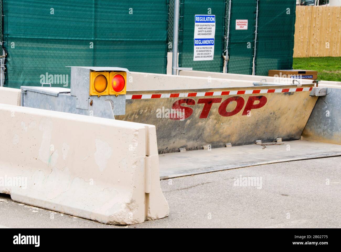 Barricada pública de cemento con una señal de stop y señales de personal autorizado solamente. Foto de stock