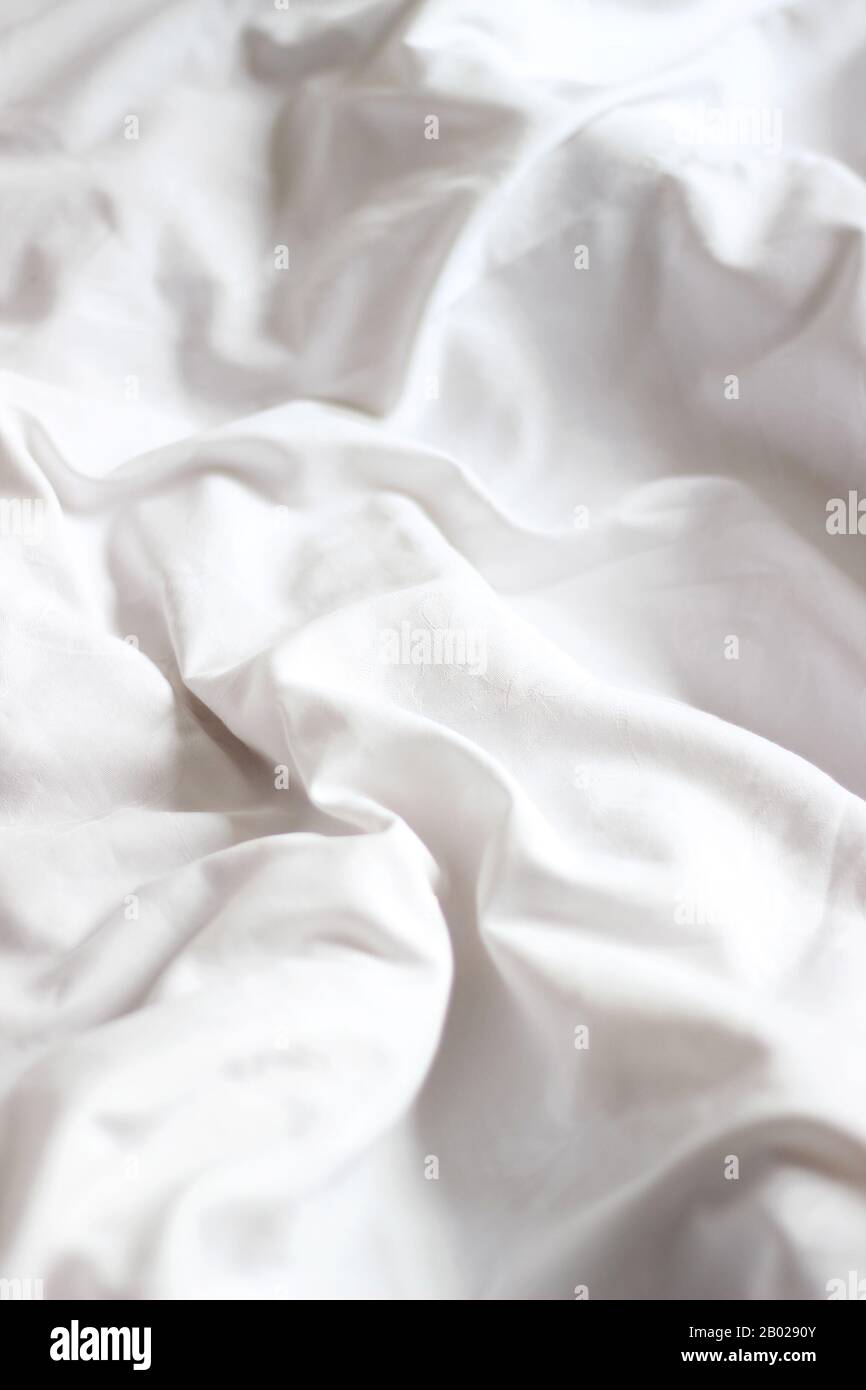 Estilo Interior Escandinavo. Sábanas blancas esponjosas en una cama no hecha. Concepto De Sueño Confortable. Foto de stock