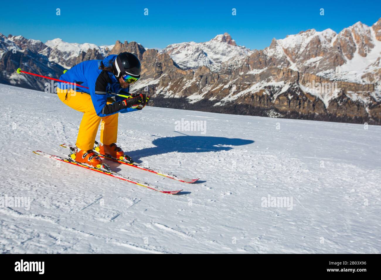 Esquiador masculino con ropa azul y amarilla en la ladera con montañas en  el fondo en Cortina d'Ampezzo Faloria estación de esquí Dolomiti Italia  Fotografía de stock - Alamy