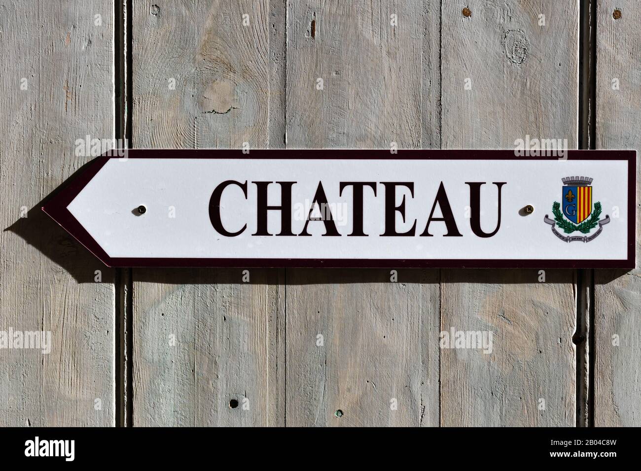 Una señal de flecha que señala al castillo ('château') escrito en francés situado en un pueblo de montaña Foto de stock