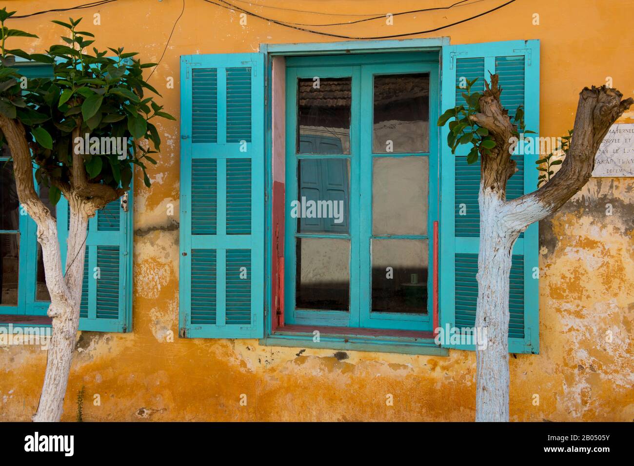 Persianas de colores de la antigua casa colonial que ahora se utiliza como  escuela en la isla Goree en el Océano Atlántico fuera de Dakar en Senegal,  África Occidental Fotografía de stock -