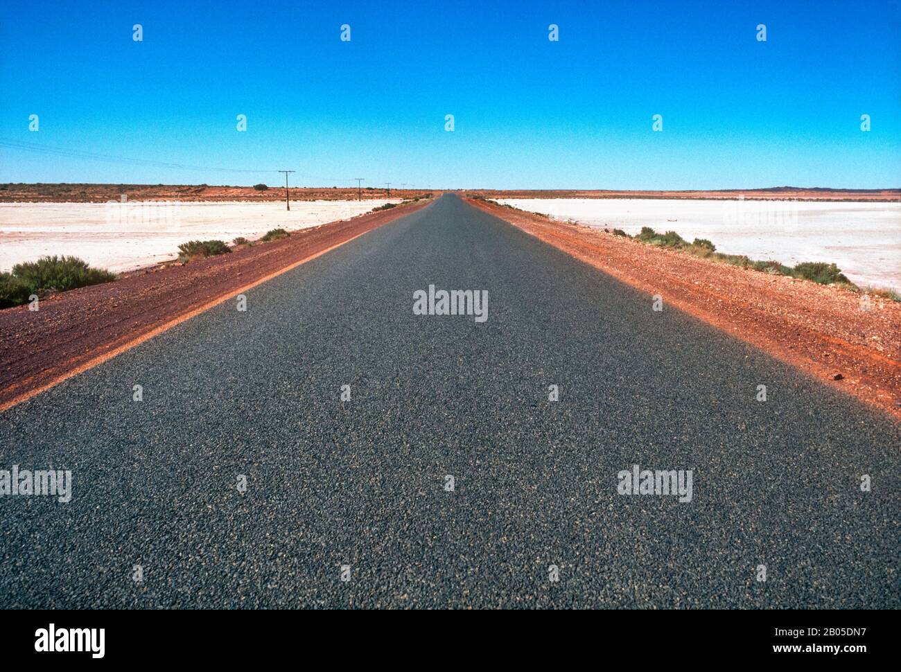 Amplia carretera abierta, carretera de betún que pasa por el país de Salt Lake, Outback, Australia Central Foto de stock