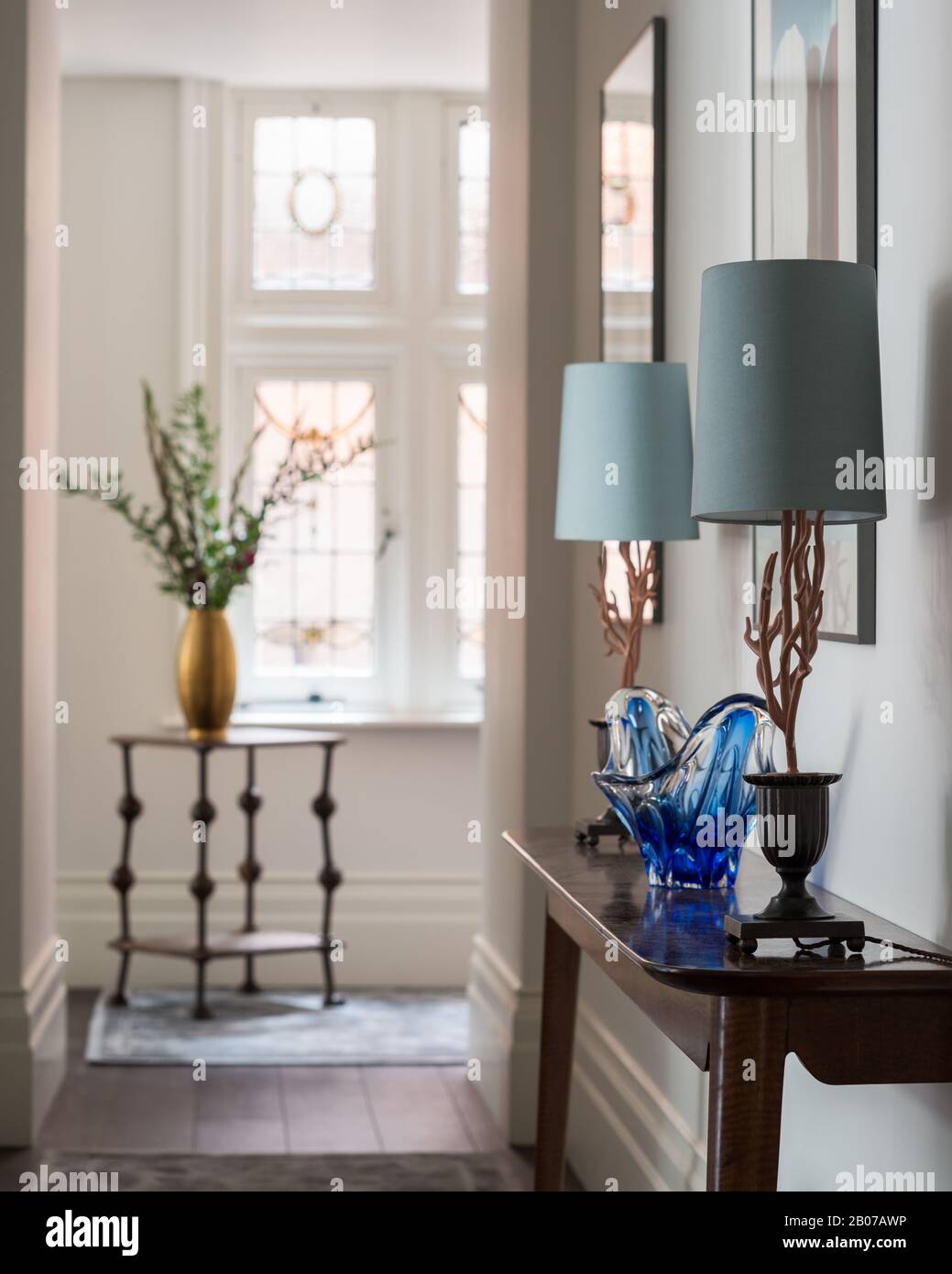 Lámparas azules y jarrón en la mesa del vestíbulo Foto de stock