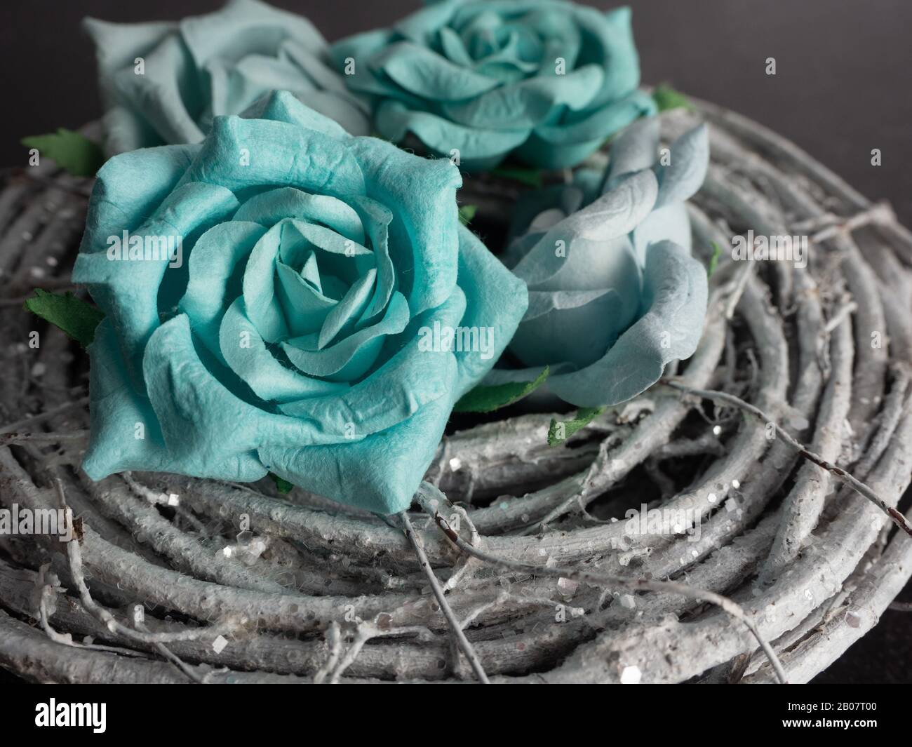Madera gris rústica enrollada como un nido con papel azul turquesa flores  de flores de rosas apiladas en un disparo macro cercano Fotografía de stock  - Alamy