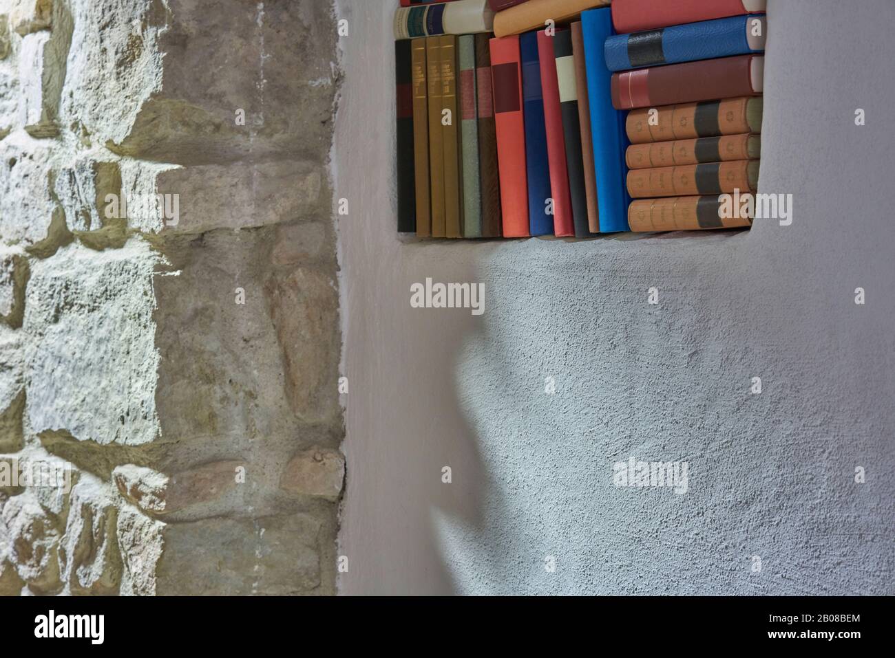 Estantería con libros y decoración cerca de la pared blanca habitación  Fotografía de stock - Alamy