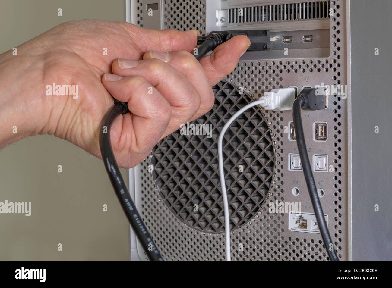 Cierre de la mano de un hombre conectando el para una pantalla/monitor en la parte posterior de un ordenador sobremesa Fotografía de stock - Alamy
