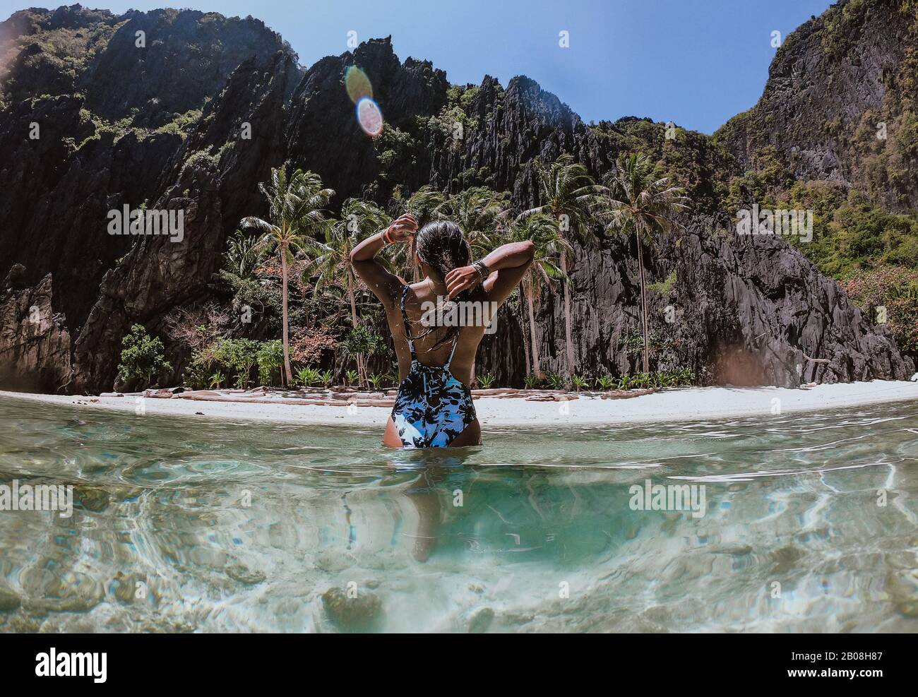 Pequeña laguna en el Nido. Mujer disfrutando del tiempo en el agua cristalina transparente, con la selva tropical en el fondo. Concepto de viajar y NAT Foto de stock