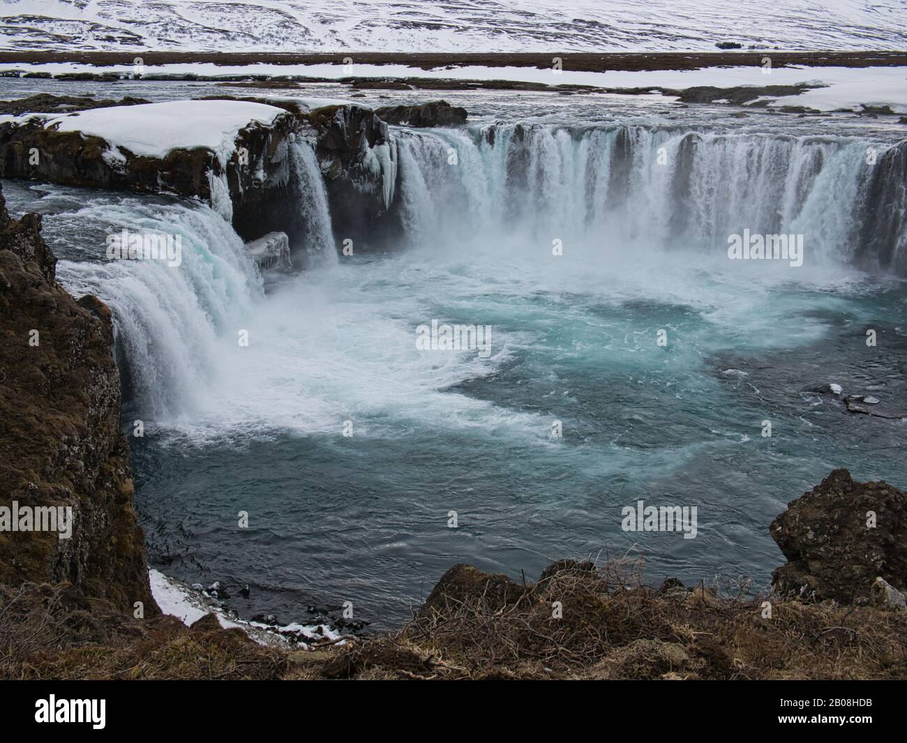 La piscina de la cascada de Godafoss en Islandia con nieve en el fondo Foto de stock