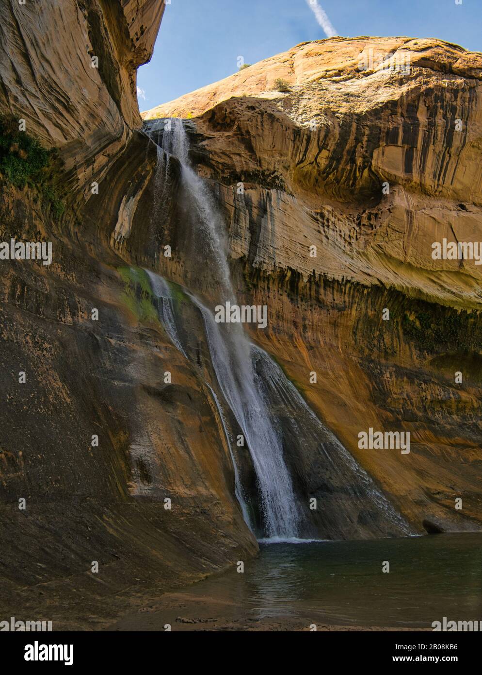 Un pequeño cañón con una cascada alta y una piscina profunda para bañarse Foto de stock